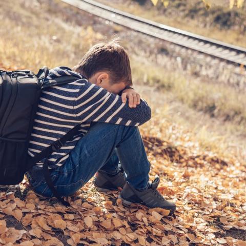 Teenager boy sitting on grass